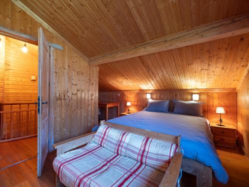 a bedroom with a bed in a wooden cabin at Les Grands Champs Sud in Faverges
