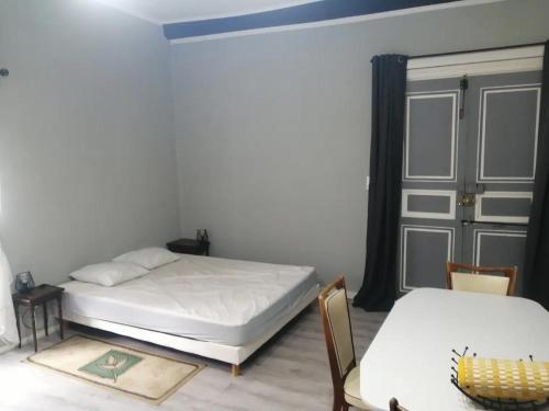 a bedroom with two beds and a table and chairs at Gradina Bulgarana in Bourg-Argental