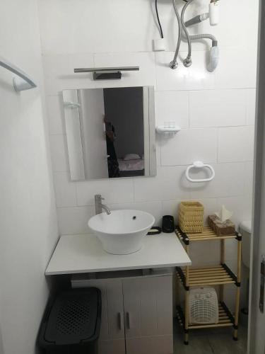 a white bathroom with a sink and a mirror at Gradina Bulgarana in Bourg-Argental