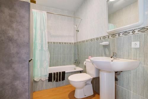 a bathroom with a sink and a toilet and a tub at Casa Tanai in El Cotillo