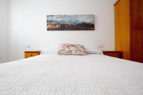 a white bed with a pillow on top of it at Casa Tanai in El Cotillo