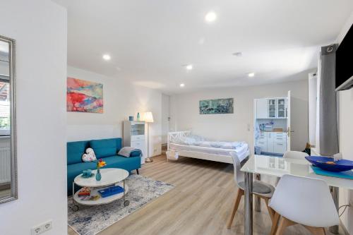 a living room with a blue couch and a bedroom at Ferienwohnung Norma in Taunusstein