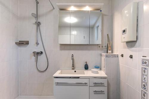 a white bathroom with a sink and a shower at Ferienwohnung Norma in Taunusstein