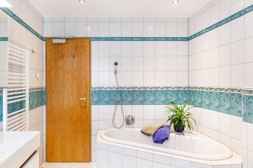 a bathroom with a tub and a plant in it at Hotel Sonnblick - Wohnung Klaus in Kartitsch