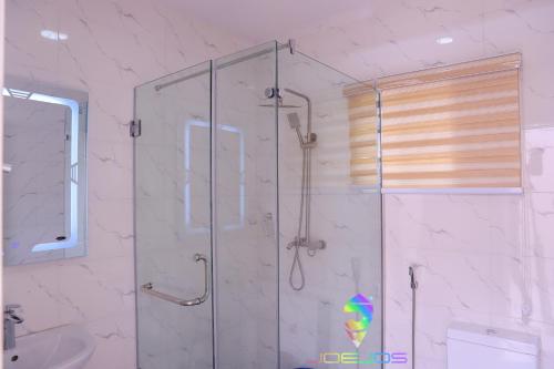 a bathroom with a shower with a glass door at Winners Aparments in Mama