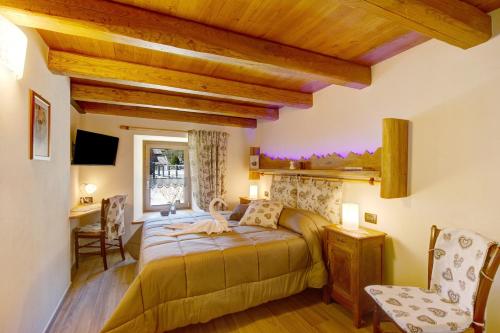 a bedroom with a bed and a desk and a chair at Appartamenti Cucu - 1 in Lillianes