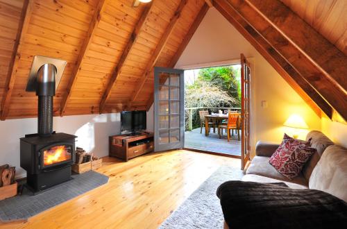 a living room with a fireplace and a couch at Santosa Cottage Sassafras in Olinda