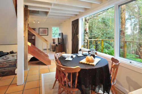 a dining room with a table and a large window at Santosa Cottage Sassafras in Olinda