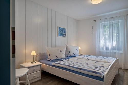 a bedroom with a large bed and a window at Ferienhäuser Ella Walter - Efeuhaus in Nordstrand