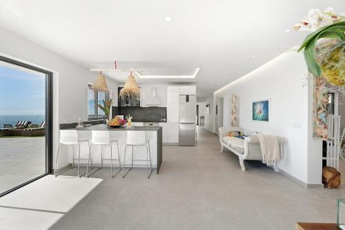 a kitchen and living room with white walls and a counter at Alba House in Adeje