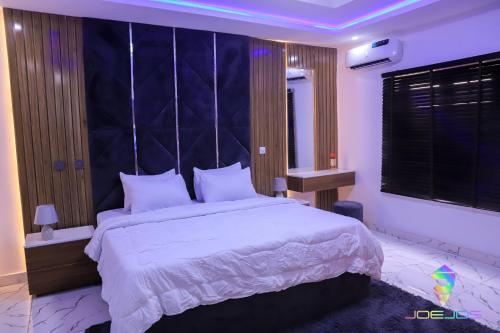 a bedroom with a large bed with a blue headboard at Winners Aparments in Mama