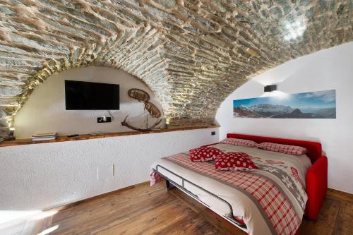 ein Schlafzimmer mit einem Bett und einer Steinwand in der Unterkunft La Cachette Relax in Aosta