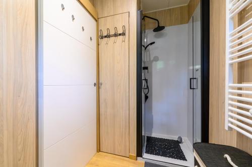 a shower in a small bathroom with a glass door at Gîte Le Pieraline - Ventron in Ventron