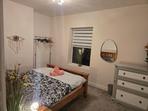 a bedroom with a bed and a dresser and a window at The Indigo Escape in Ibstock