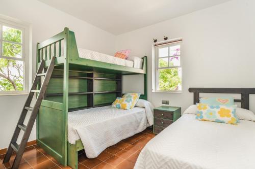 a green bunk bed in a room with two beds at Casa Ullastre de Fornells in Fornells