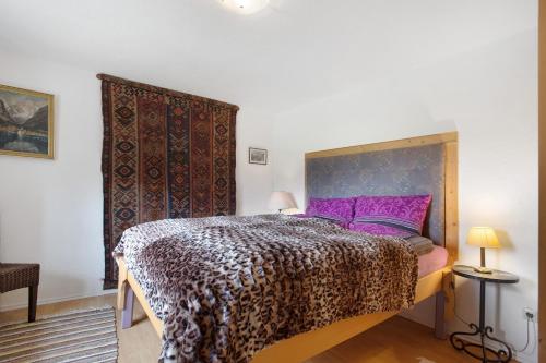 a bedroom with a bed with a purple bedspread at Ferienwohnung beim Roana in Inzell