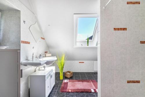 a white bathroom with a sink and a shower at Ferienwohnung Kiebitznest in Kaiser Wilhelm Koog