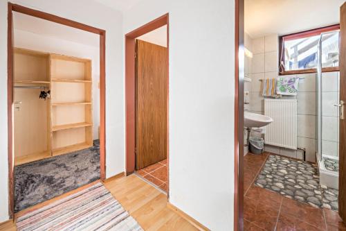 a bathroom with a door and a sink and a mirror at Ferienwohnung Zillertalblick in Stummerberg
