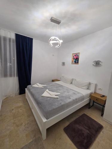 a bedroom with a large bed and a chandelier at Fabian Apart CenterTown in Tulcea