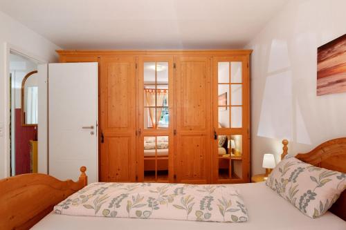 a bedroom with a bed and a wooden cabinet at Ferienwohnung am Waldrand in Alpirsbach