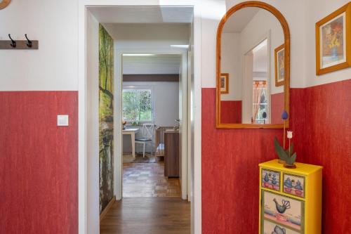 a hallway with red and white walls and a yellow cabinet at Ferienwohnung am Waldrand in Alpirsbach