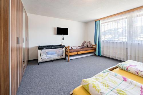 a hotel room with two beds and a television at Ferienwohnung Zillertalblick in Stummerberg