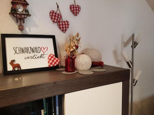a table with a picture and a framed picture on it at Ferienwohnung Schöner in Oberharmersbach