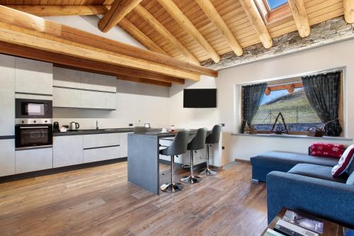 a kitchen and living room with a blue couch at Alpine A-S in Aymavilles