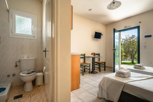 a bedroom with a toilet and a bathroom with a table at Anemona studio B in Kefallonia
