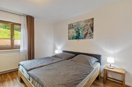 a bedroom with a bed with a picture on the wall at Hof Helmenhube 2 in Oberzent
