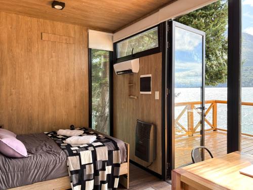 a bedroom with a bed and a balcony at Cabaña sobre Playa Lago Gutierrez 1 in San Carlos de Bariloche