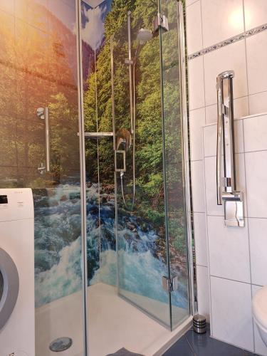 a bathroom with a shower with a painting of a river at Hinterbauernhof Fewo Pferdeglück in Stegen