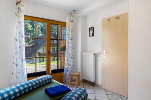 a living room with a couch and a large window at Hinterbauernhof Fewo Pferdeglück in Stegen