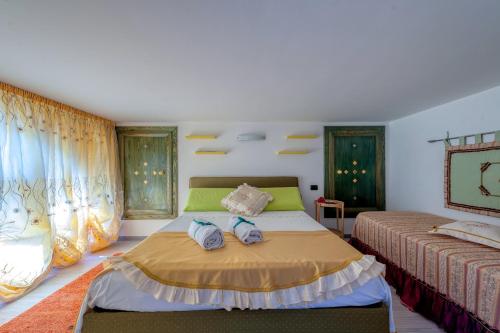 a bedroom with a bed and two beds with towels at Il Geco in Salice Salentino