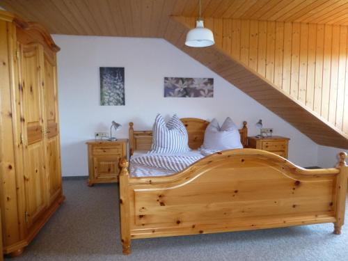 a bedroom with a wooden bed in a attic at Moorwiesenhof in Ostrach