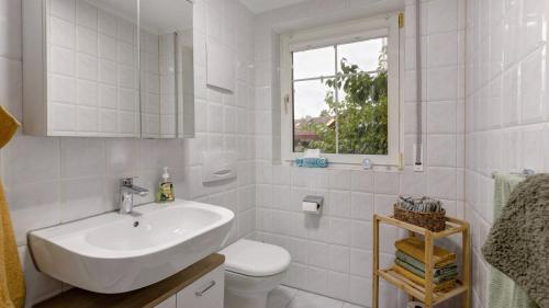 a white bathroom with a sink and a toilet at Ferienwohnung Heidegarten in Radolfzell am Bodensee