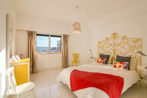 a bedroom with a large bed with a red blanket at Modern Apartment by the Sea in Quarteira