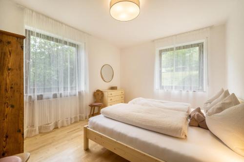una camera da letto bianca con un letto e una finestra di Villa Pinie Apt 2 a Terlano