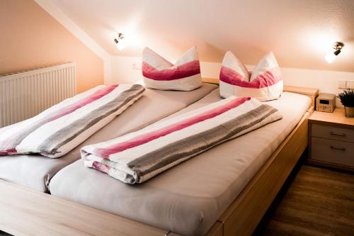 two beds with pink and white pillows on them at Paradies Im Schwarzwald in Bad Peterstal-Griesbach