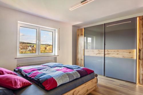 ein Schlafzimmer mit einem Bett und zwei Fenstern in der Unterkunft Sauerlandrefugium in Medebach