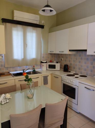 a kitchen with a table with a vase of flowers on it at Anemi Leros Apartments 4 in Panteli