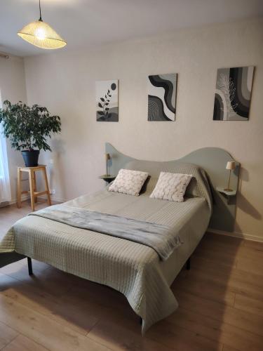 a bedroom with a large bed with two pillows at L échappée verte in Gien