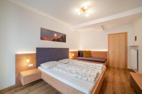 a bedroom with a large bed and a couch at Haus Hohenrain Ferienwohnung 1 in Schenna
