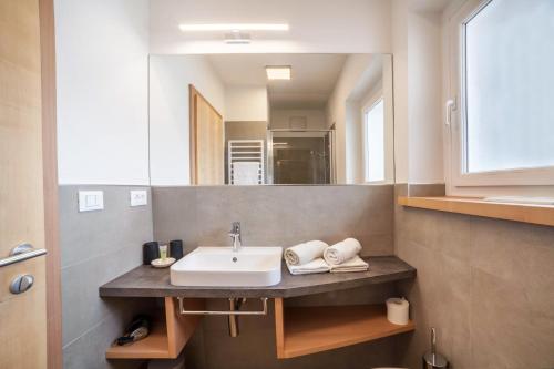 a bathroom with a sink and a mirror at Haus Hohenrain Ferienwohnung 1 in Schenna