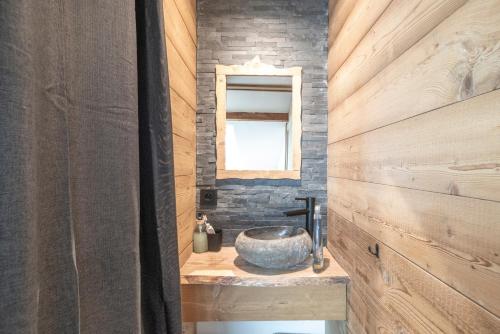 a bathroom with a stone sink and a mirror at Le Chappart - Carroz d'Arâches in Arâches-la-Frasse