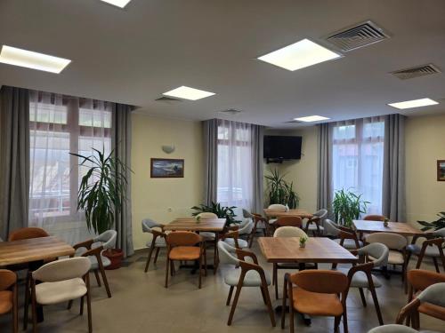 a restaurant with wooden tables and chairs and windows at Yagodina Family Hotel in Yagodina
