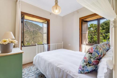 a bedroom with a bed and two windows at Caldera de Taburiente Rural in El Paso