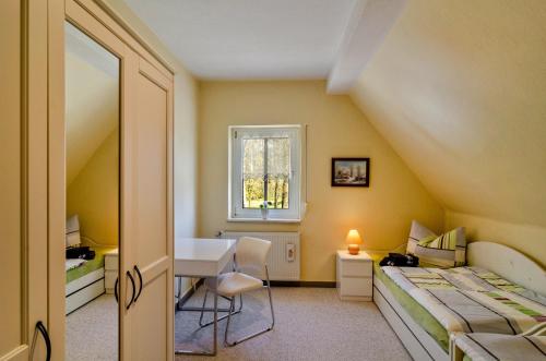 a bedroom with a bed and a desk and a window at Ferienhaus am Park in Heudeber