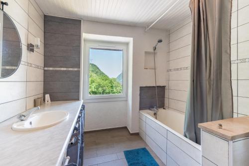 a bathroom with a sink and a tub and a window at Au Milan D'ore - Pyrénées in Gère-Belesten