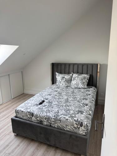 a bedroom with a bed with a gray bed frame at Appartement 3 morangis in Morangis